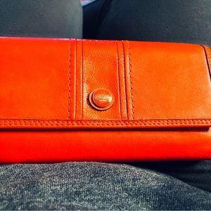 Red Coach leather chkbk wallet. Storage for cards back has zippered compartment